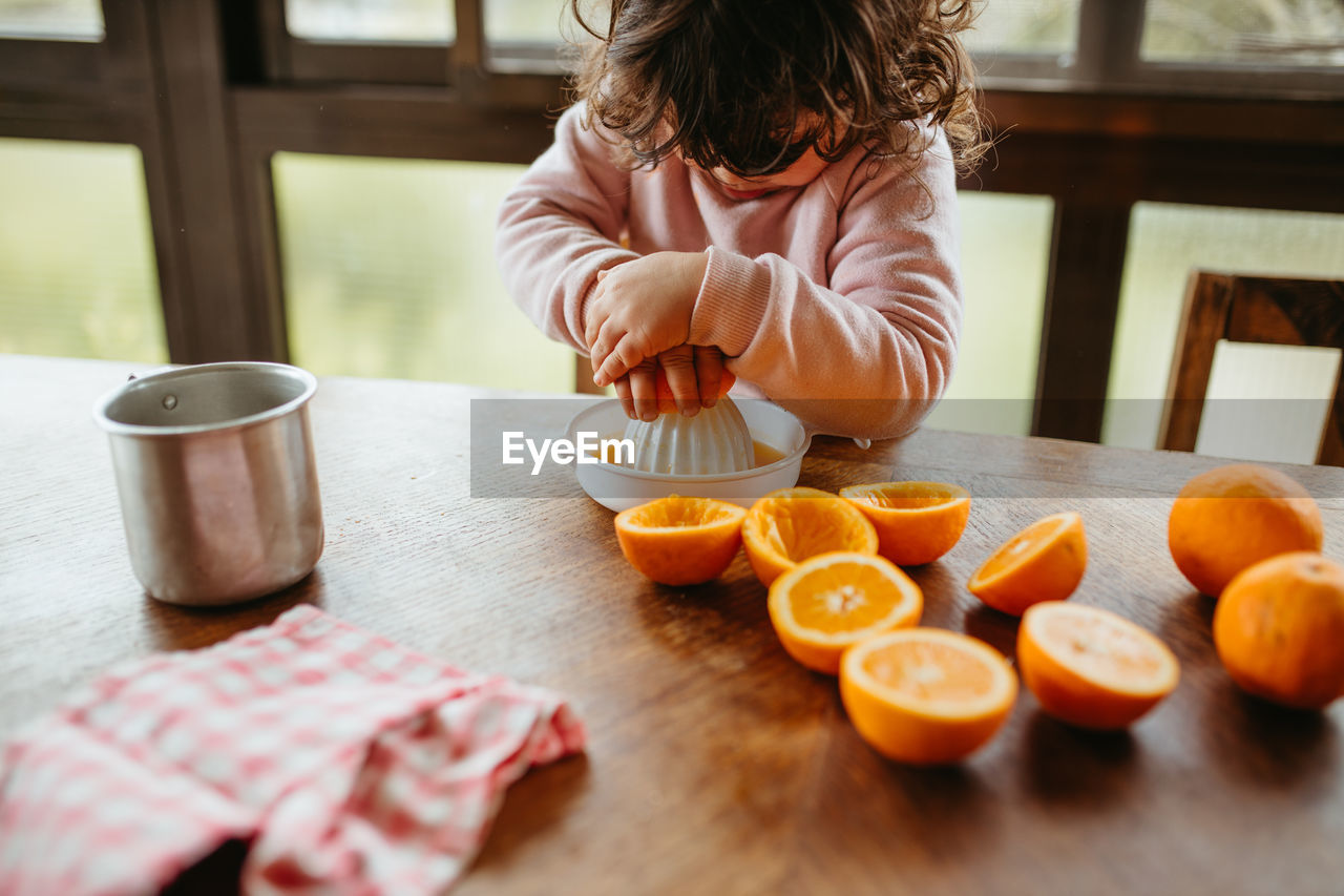 Cute girl preparing juice at home