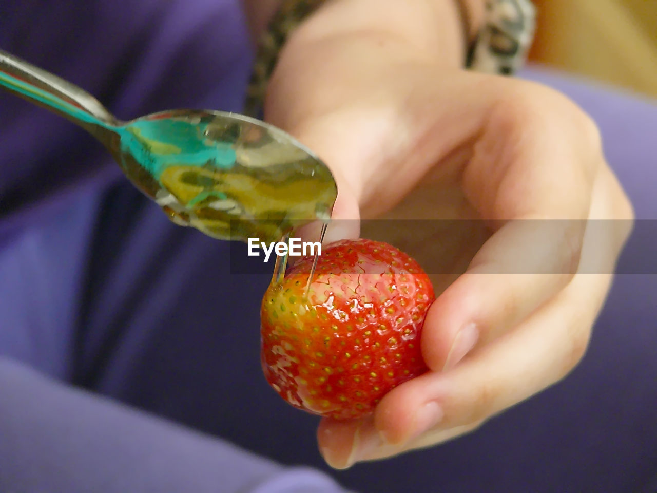 CLOSE-UP OF HAND HOLDING STRAWBERRIES