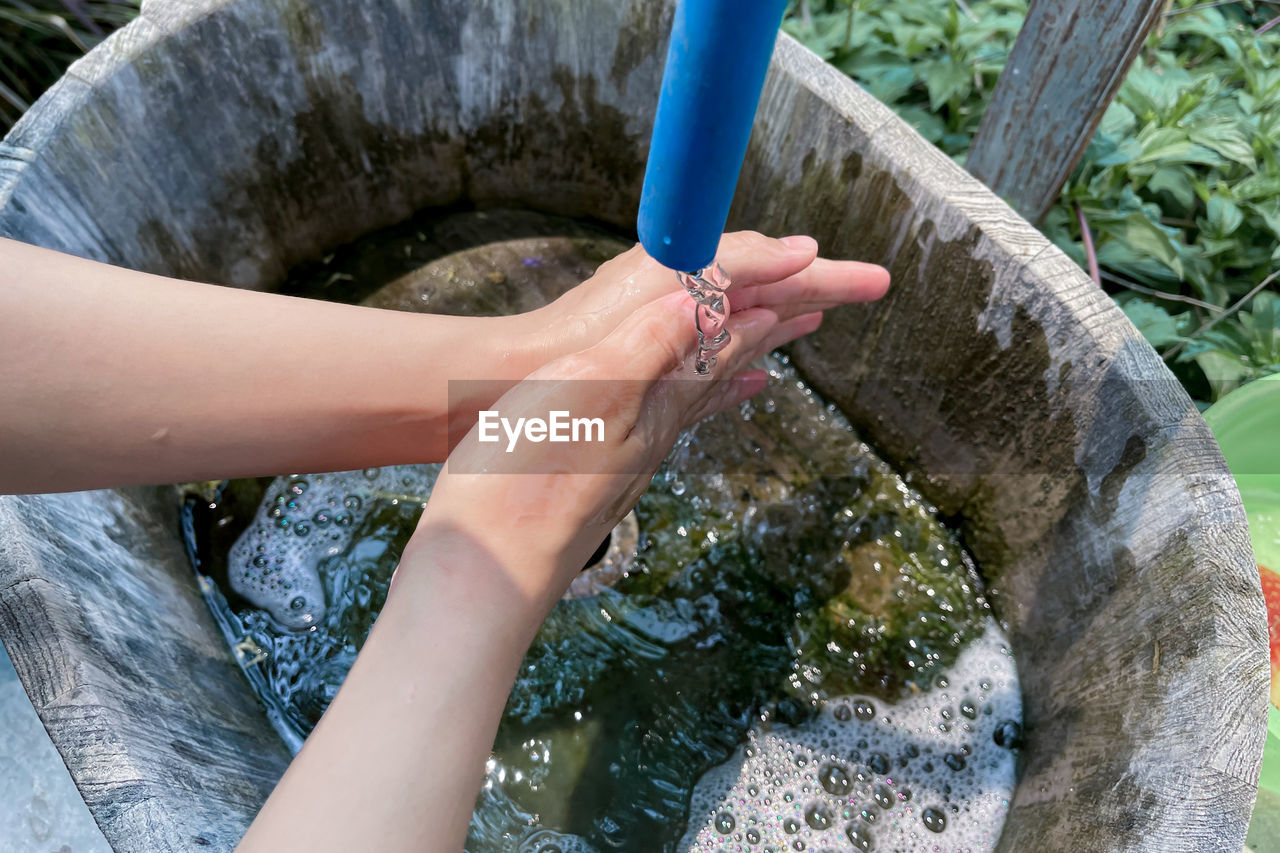 HIGH ANGLE VIEW OF WOMAN HAND ON ROCKS