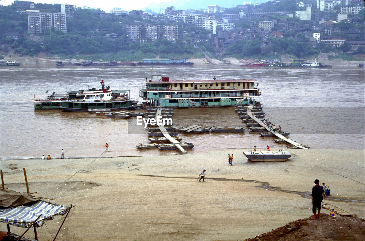 HIGH ANGLE VIEW OF PEOPLE ON BOAT AT SEA