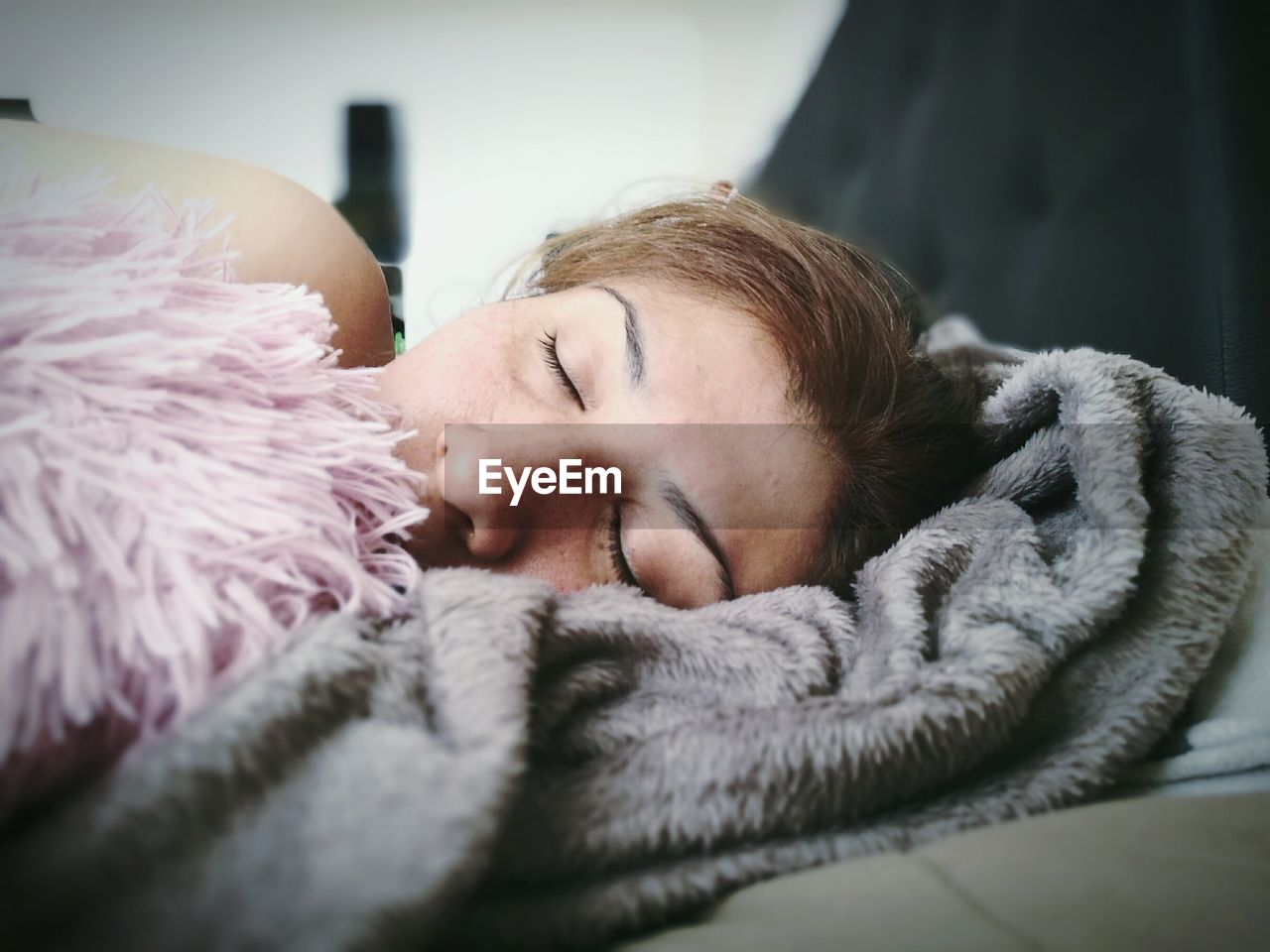 Close-up of woman sleeping on bed at home