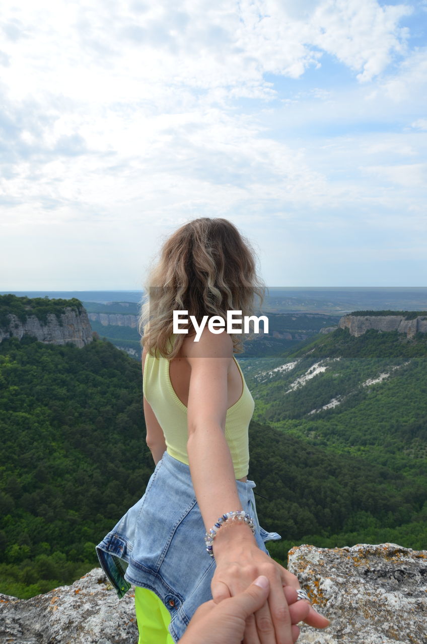 Young woman looking at sea against sky