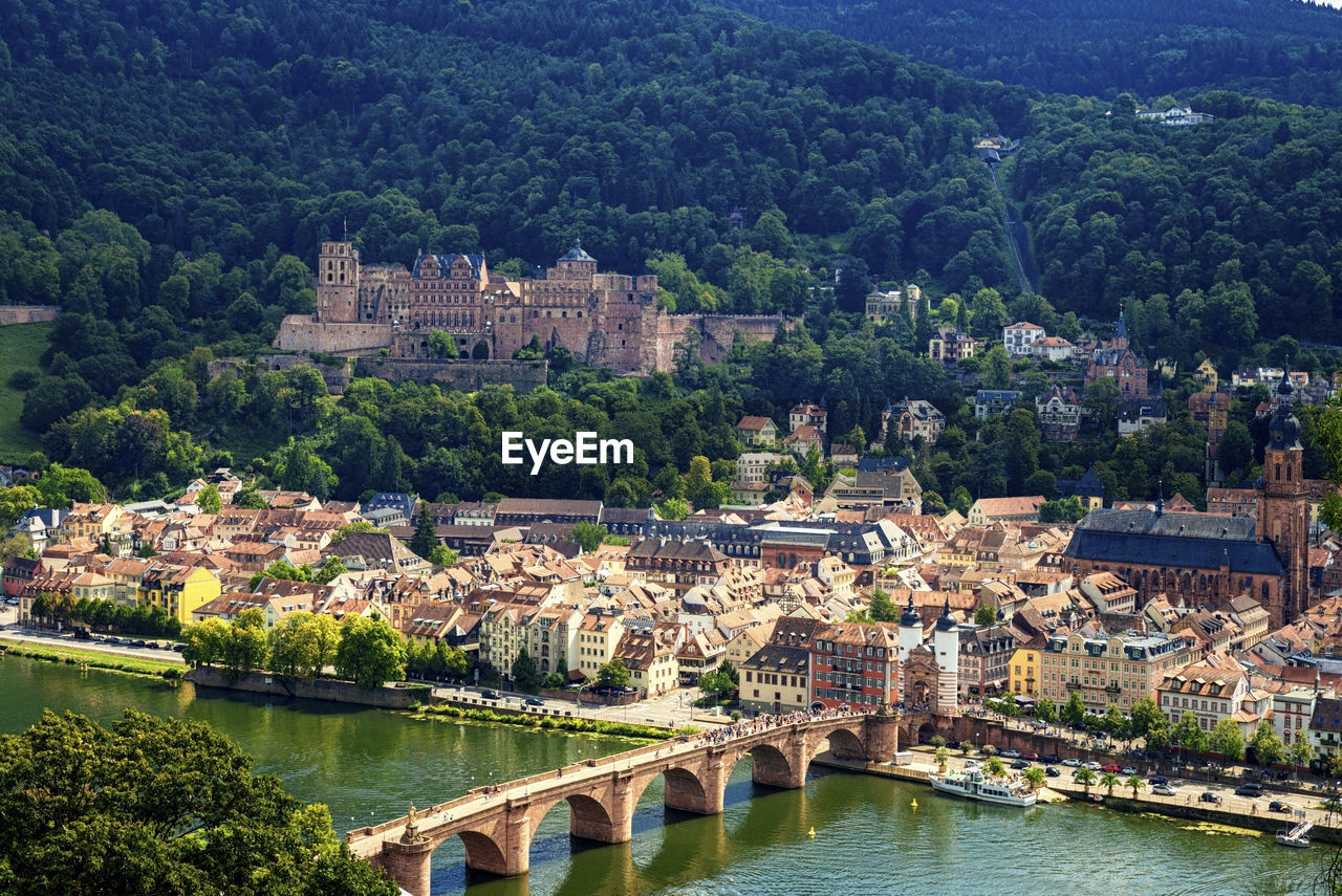 HIGH ANGLE VIEW OF BRIDGE OVER RIVER AMIDST BUILDINGS