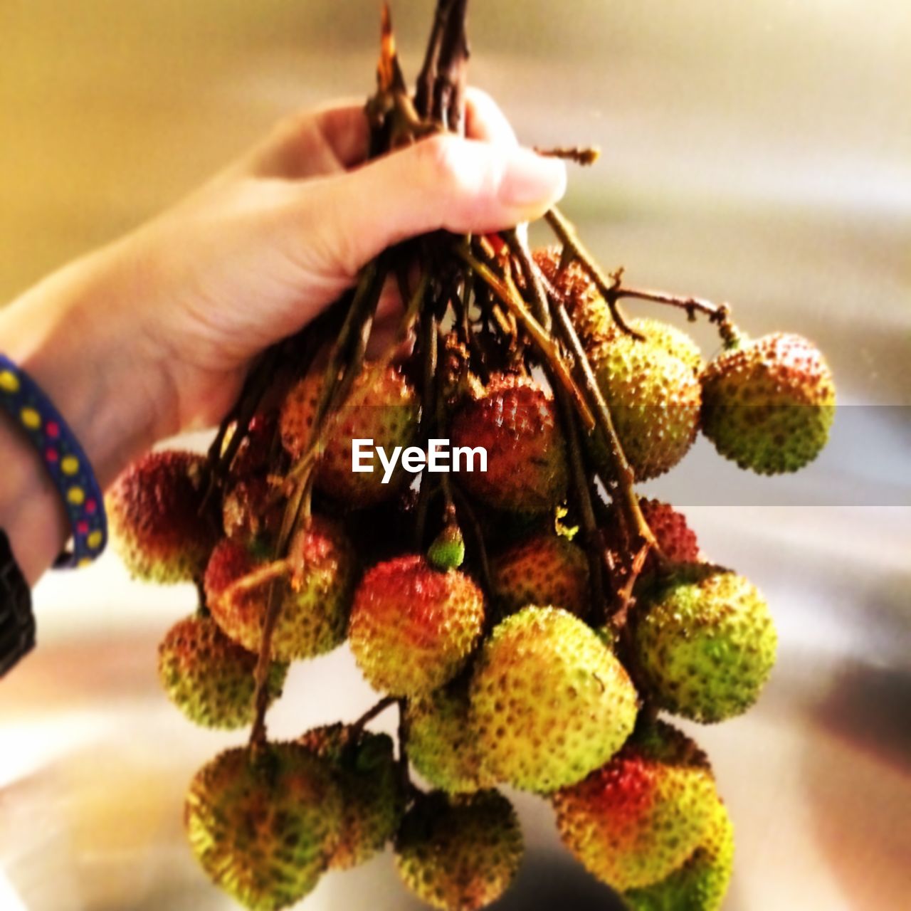 CLOSE-UP OF HAND HOLDING STRAWBERRY