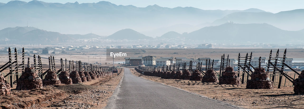 SCENIC VIEW OF ROAD LEADING TOWARDS MOUNTAINS