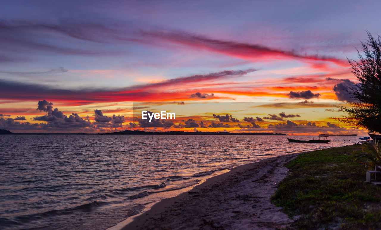 sky, sunset, water, cloud, sea, beauty in nature, nature, evening, scenics - nature, land, dawn, horizon, landscape, travel destinations, environment, coast, beach, afterglow, dramatic sky, tranquility, orange color, architecture, travel, shore, multi colored, no people, outdoors, city, sun, tranquil scene, ocean, reflection, tourism, romantic sky, plant, seascape, holiday, tree, trip, vacation, transportation, coastline, twilight, urban skyline