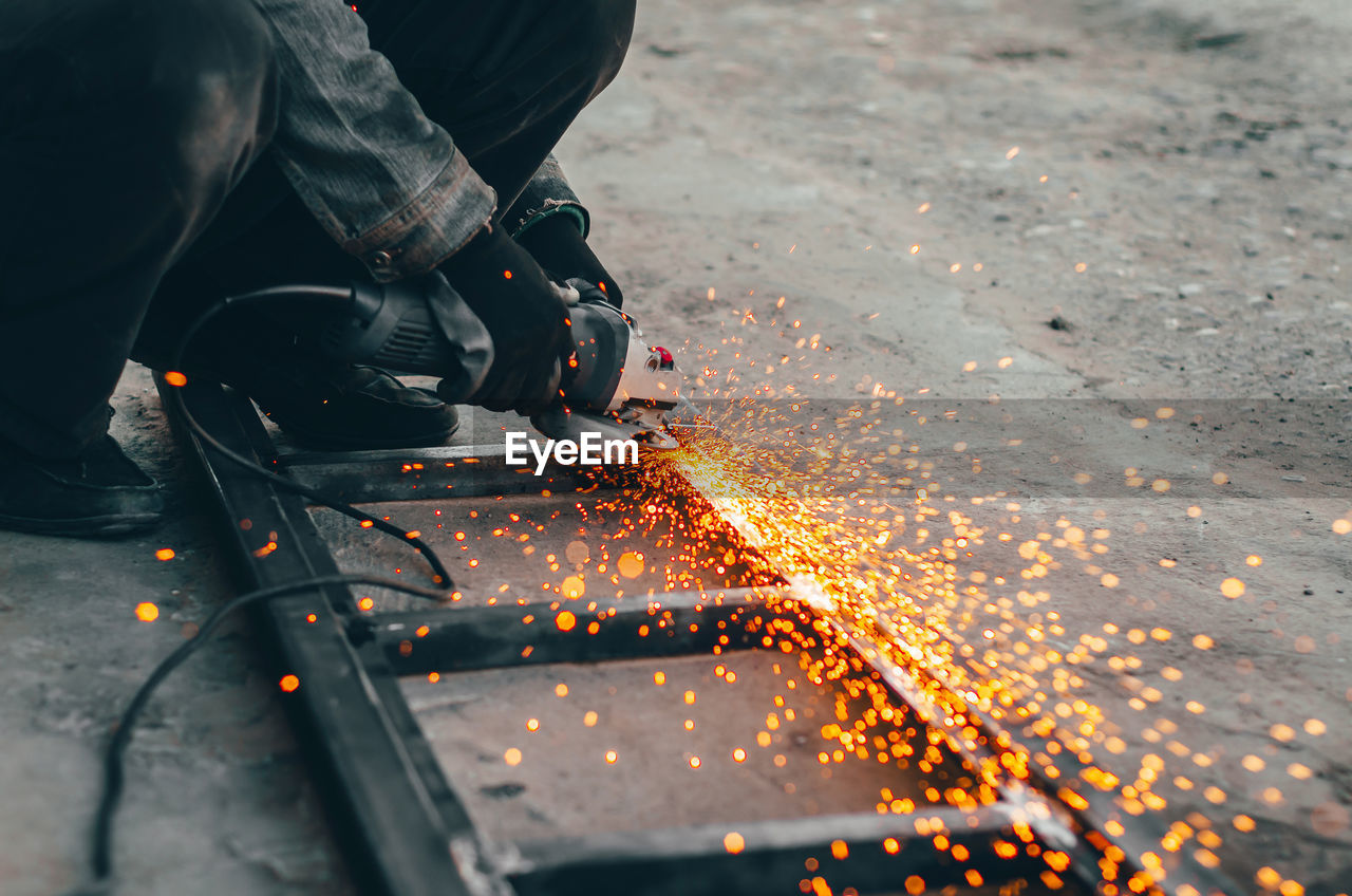 LOW SECTION OF MAN WORKING ON METAL WITH FIRE