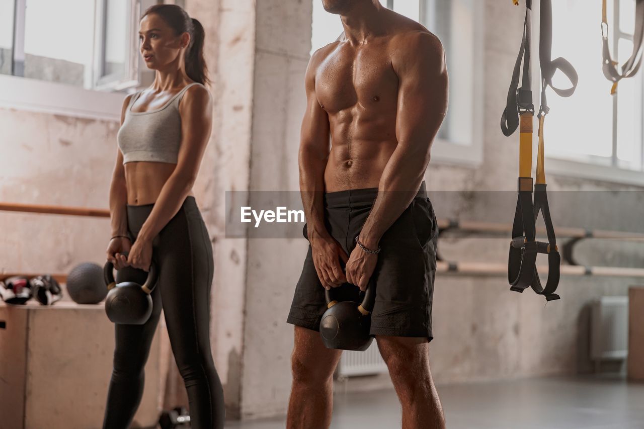 rear view of shirtless man exercising in gym