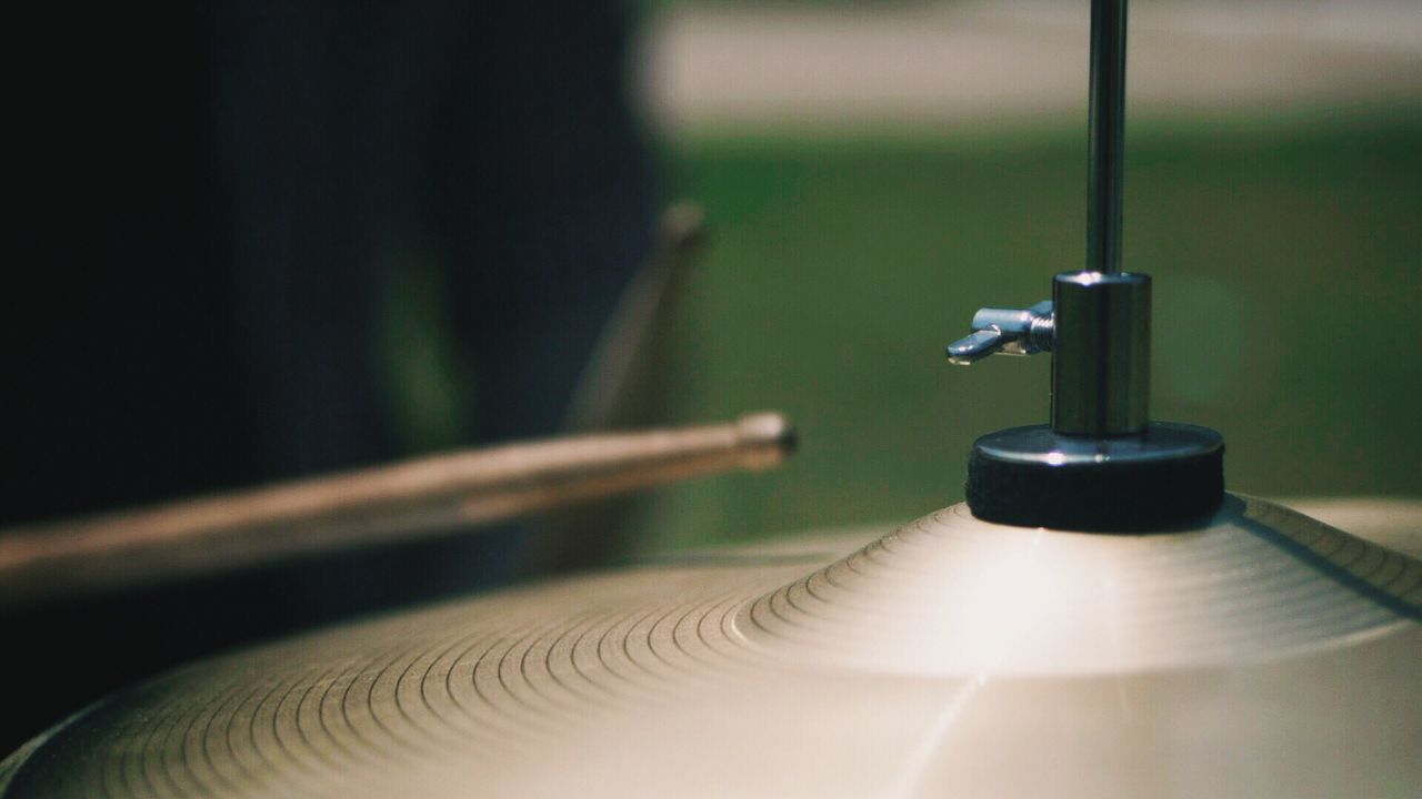 Close-up of cymbal with drumsticks