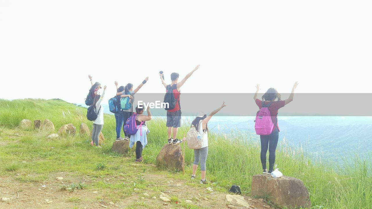 LOW ANGLE VIEW OF FRIENDS JUMPING