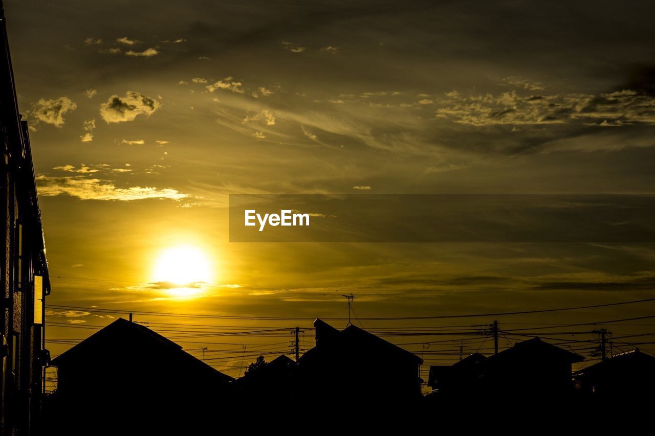 Exterior of houses against sky at sunset