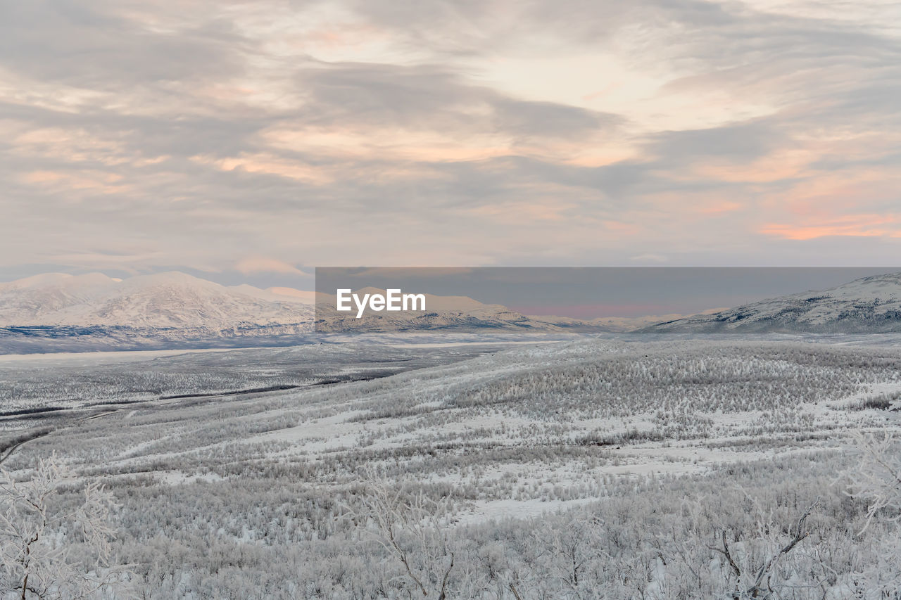 Scenic view of snowcapped mountains against sky during sunset
