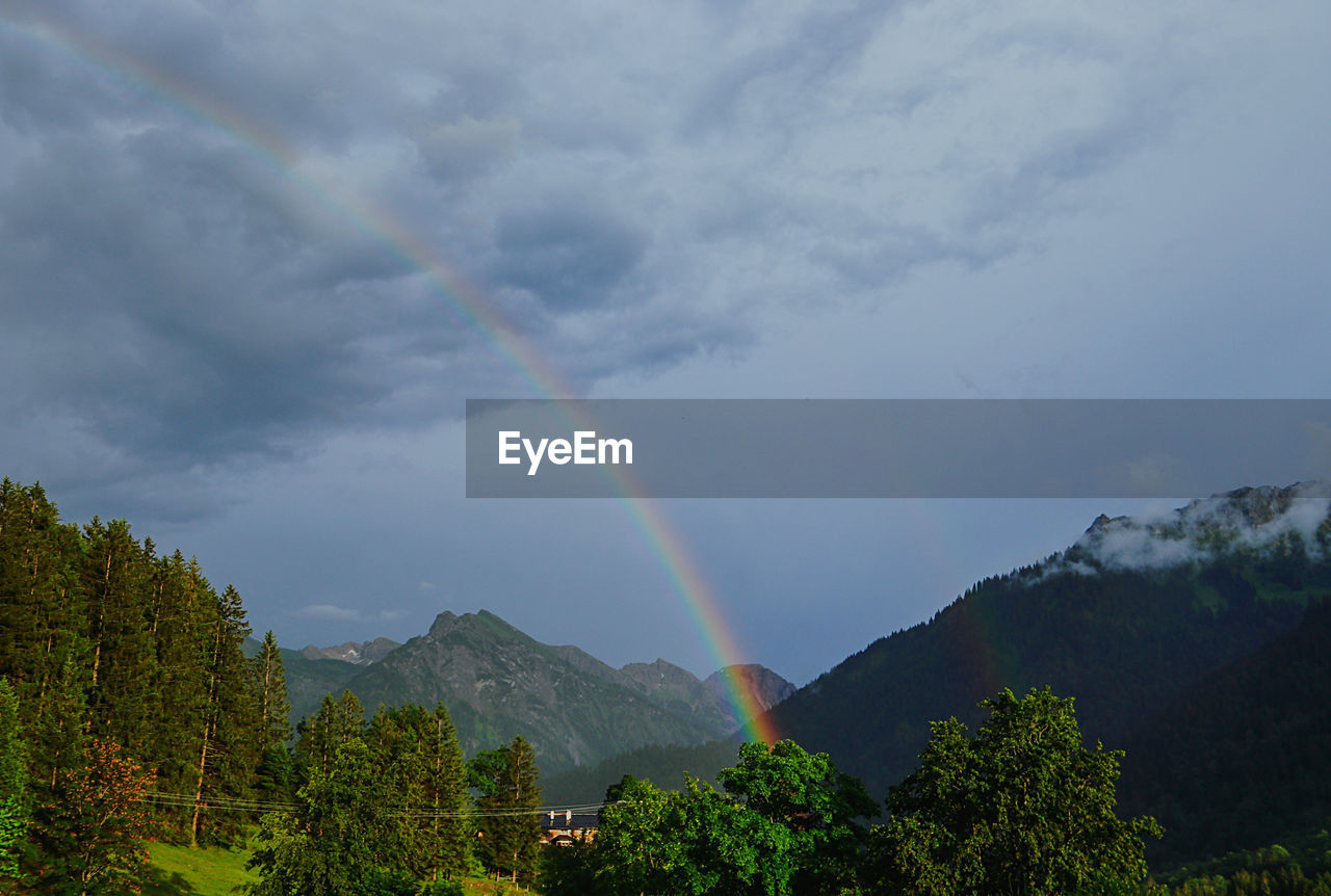 Scenic view of rainbow over mountains against sky