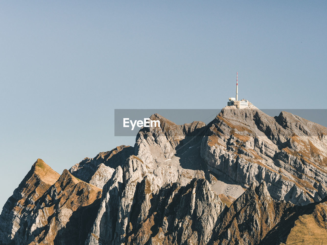 Low angle view of rocks and mountain against clear sky