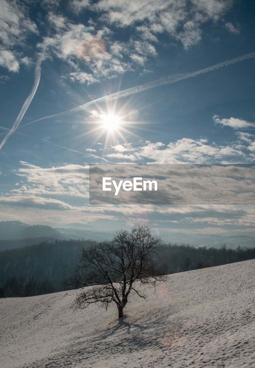 SCENIC VIEW OF SNOW COVERED LAND AGAINST BRIGHT SKY