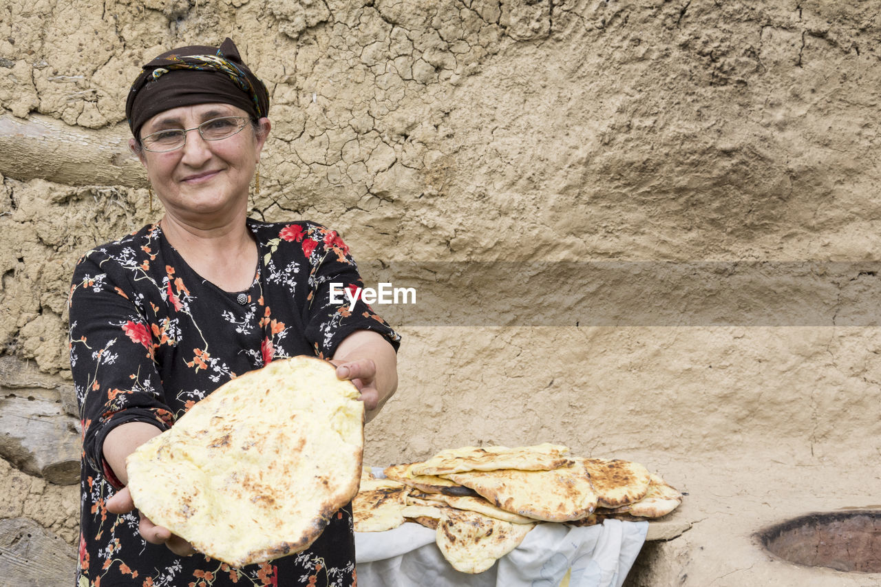 Portrait of smiling woman holding bread