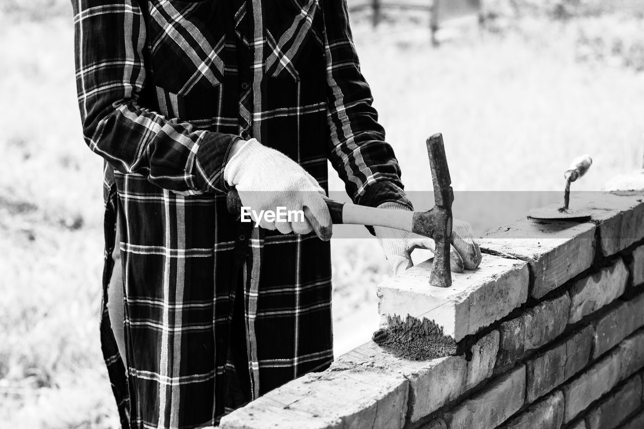 Young woman builds a wall of bricks