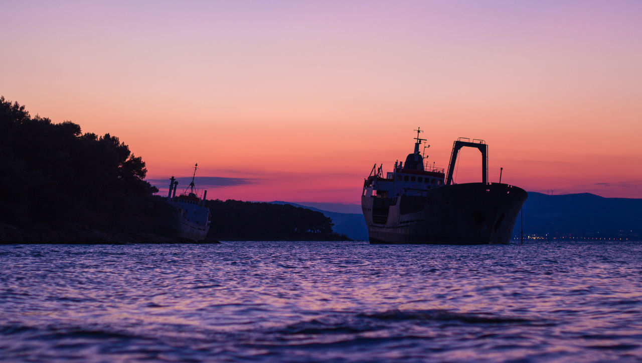 Boat in sea at sunset