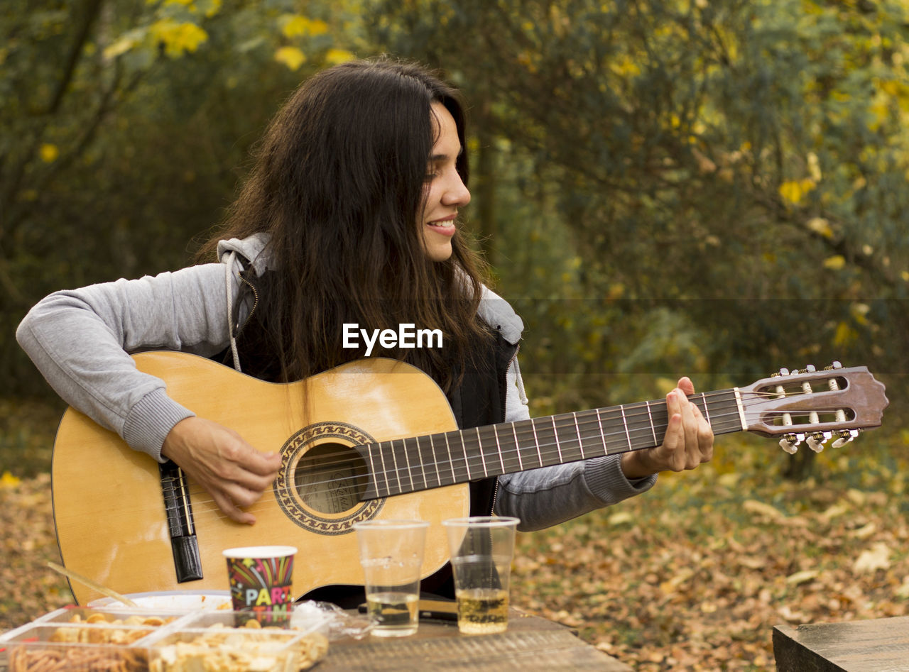 Young woman playing guitar outdoor