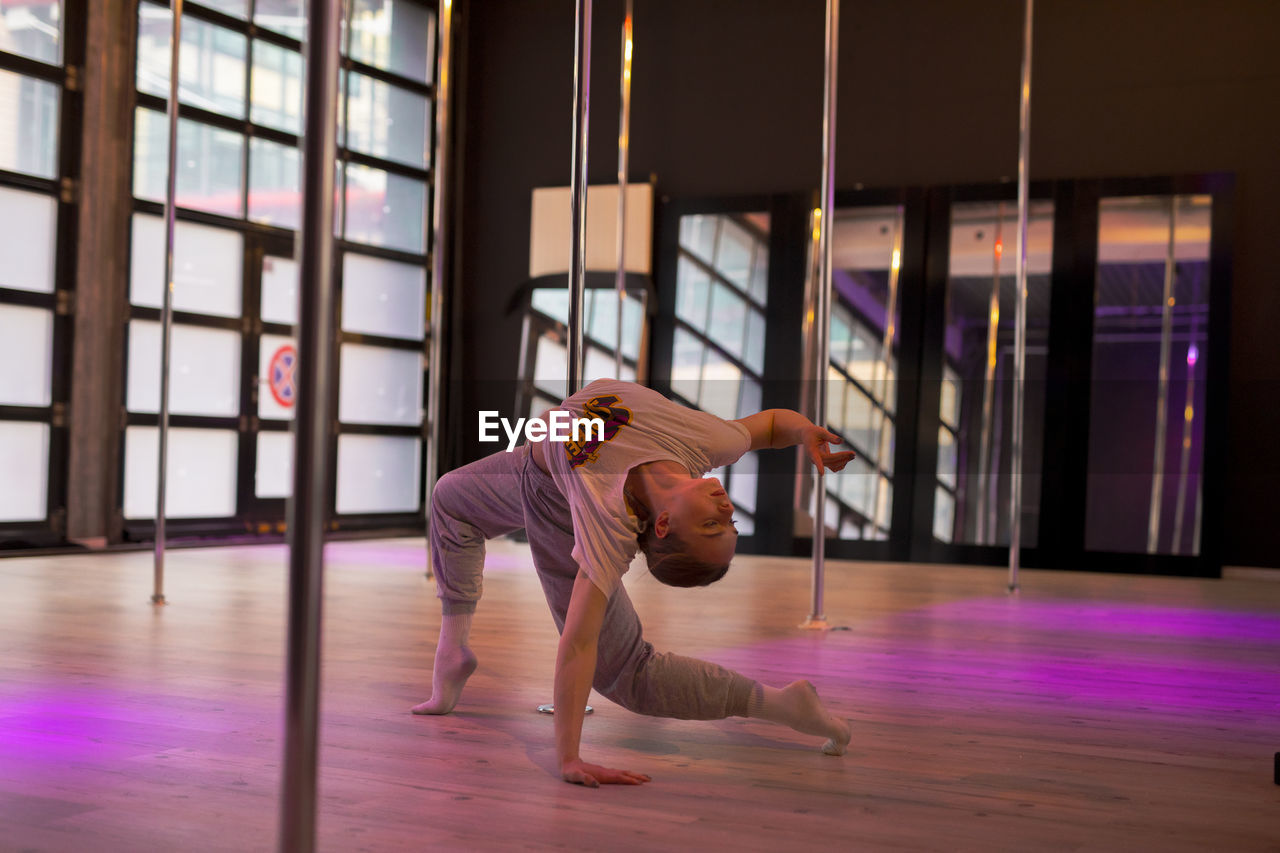 Side view of woman jumping in gym