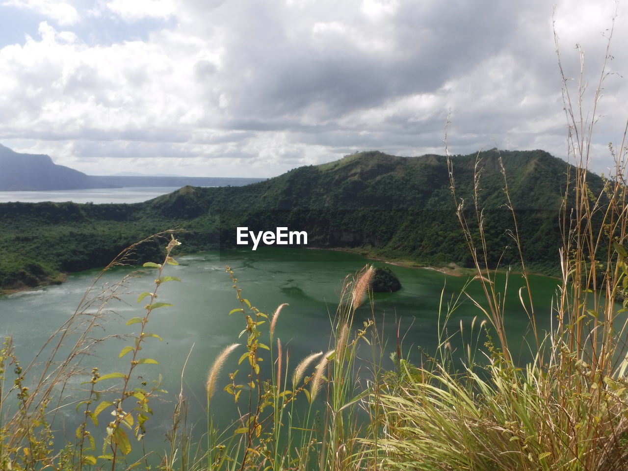 Scenic view of lake and mountains against cloudy sky