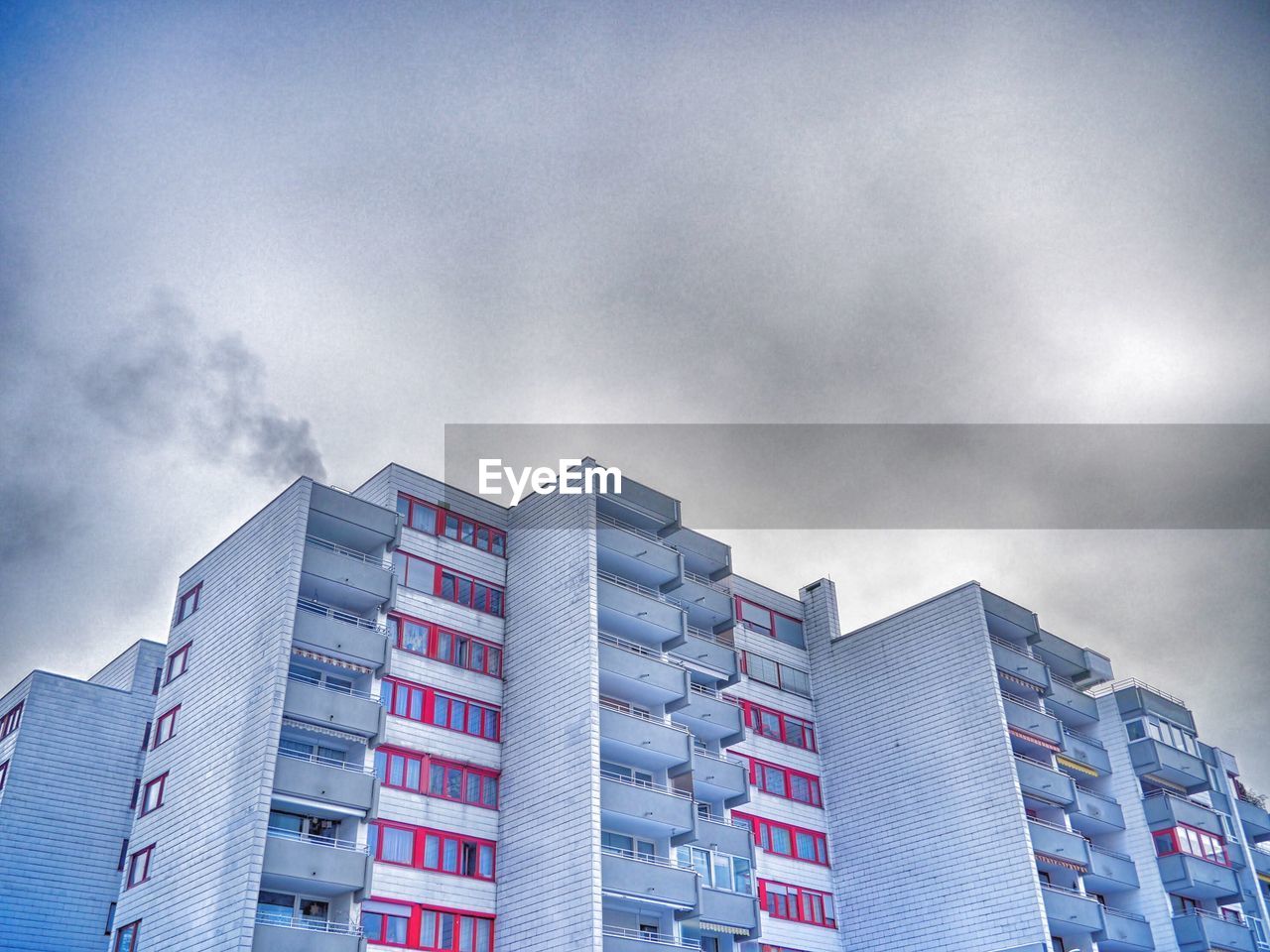 Low angle view of buildings against cloudy sky