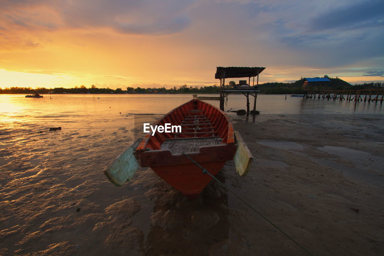 BOAT MOORED ON SEA AGAINST SKY DURING SUNSET