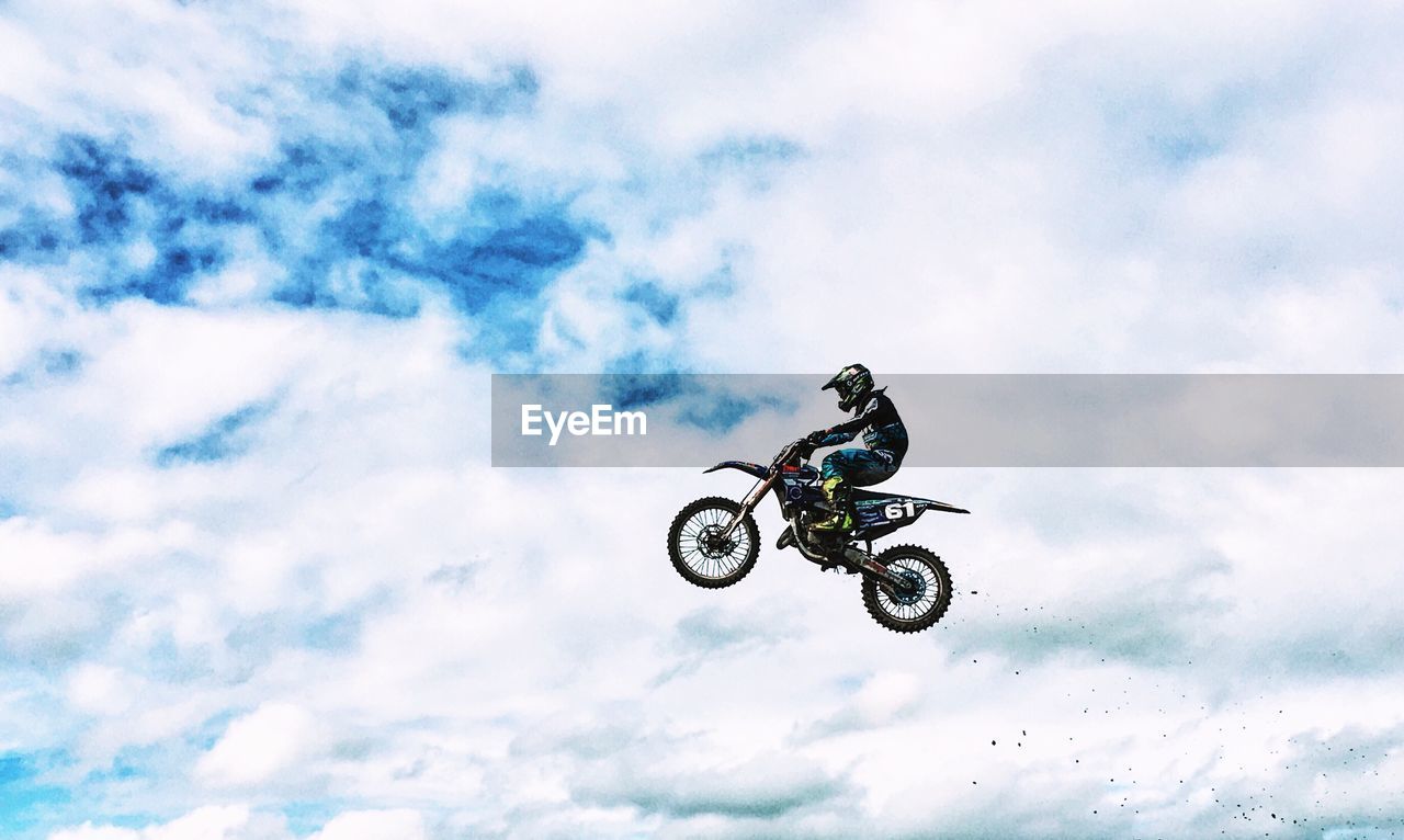 Low angle view of man riding motorcycle against sky