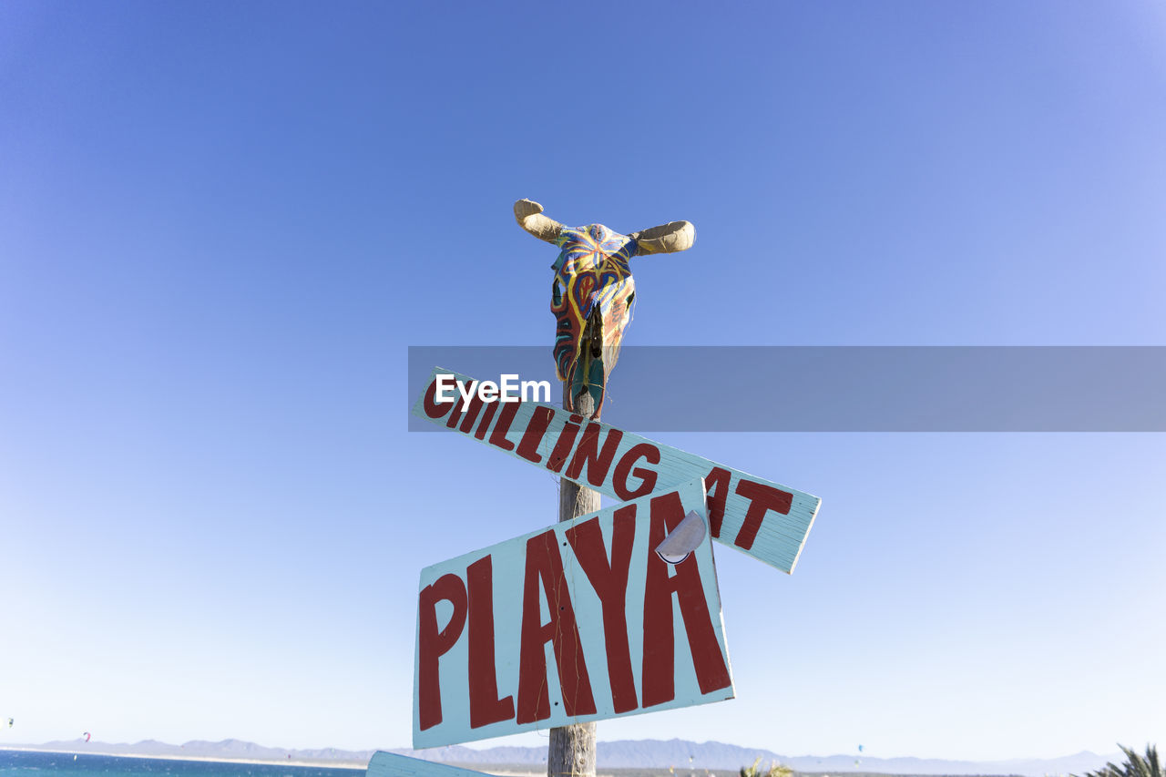 LOW ANGLE VIEW OF SIGN BOARD AGAINST CLEAR SKY