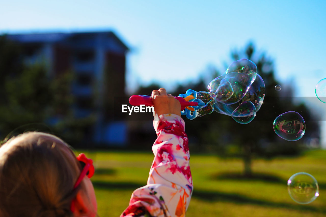 GIRL PLAYING WITH BUBBLES