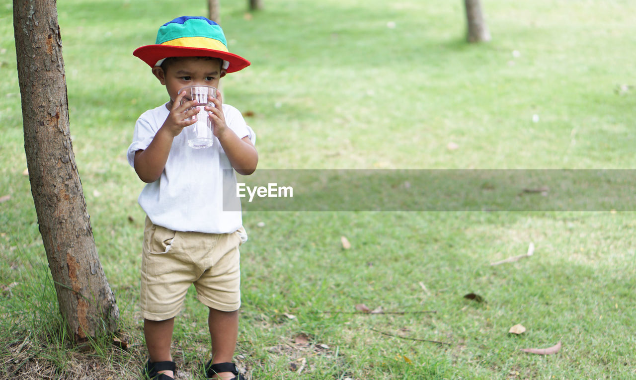 Boy drinking water in park