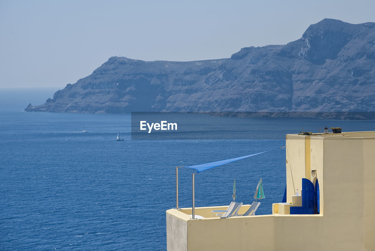 Scenic view of sea and mountains against clear sky