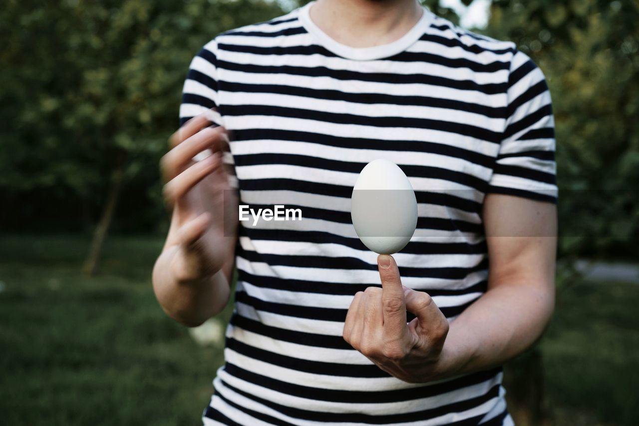 Midsection of man holding egg