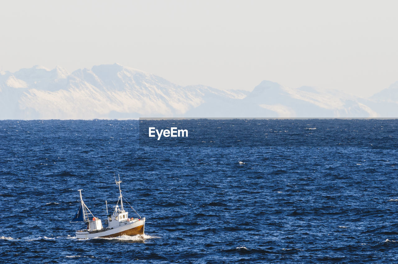 Boat on sea, iceberg on background