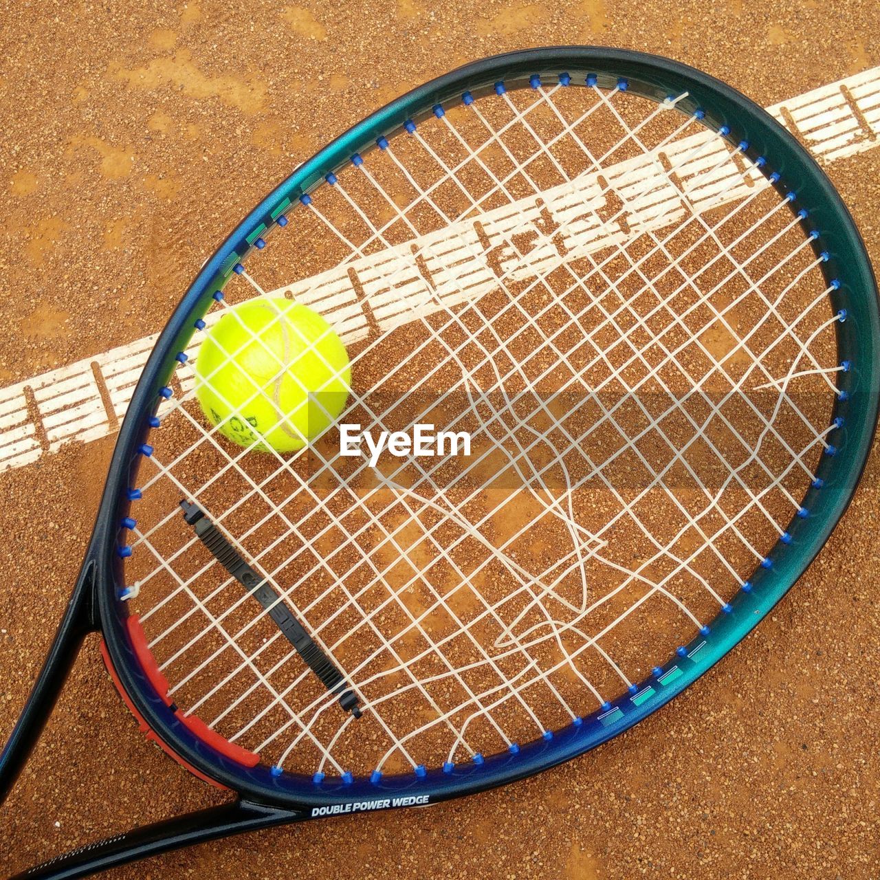 Broken tennis racket with ball