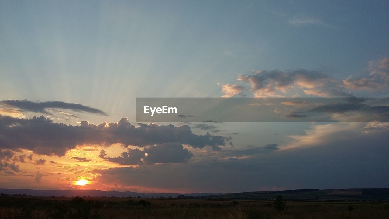 Scenic view of landscape against sky at sunset