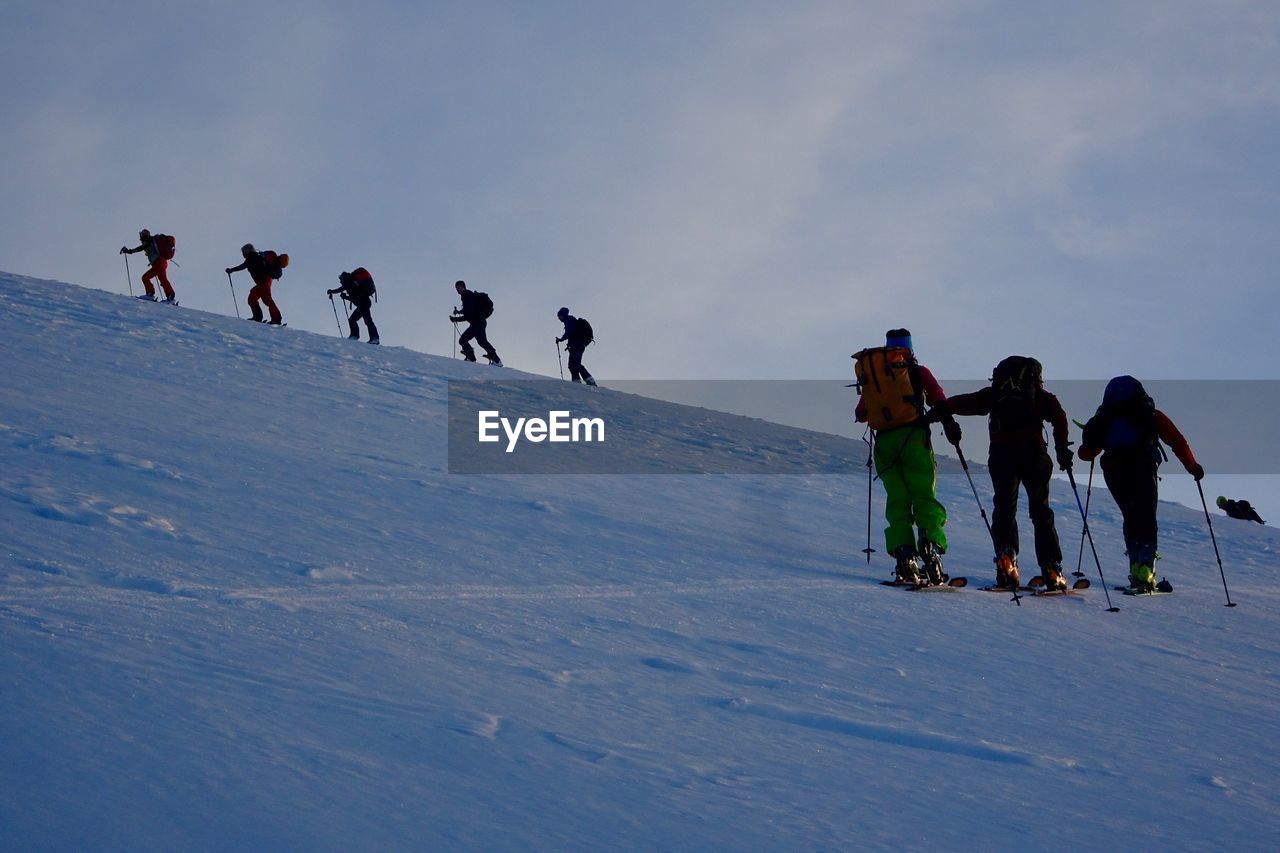 People skiing on snow covered landscape during winter