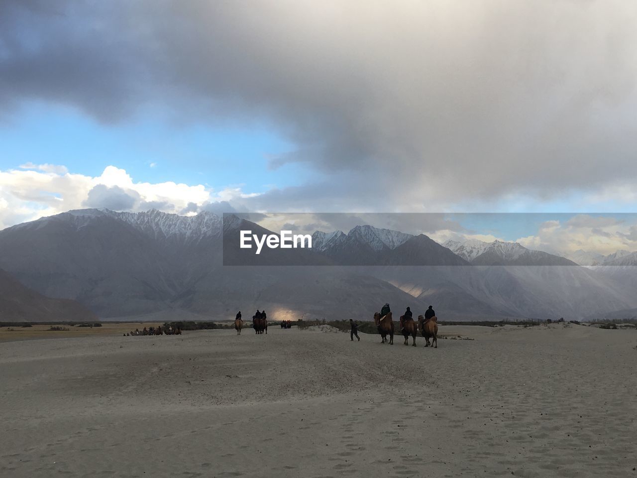 People on snowcapped mountains against sky