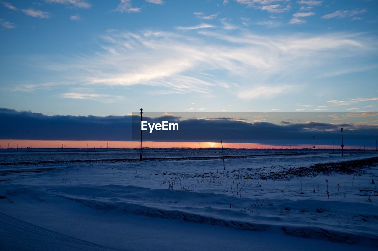 Scenic view of snowcapped landscape at sunset