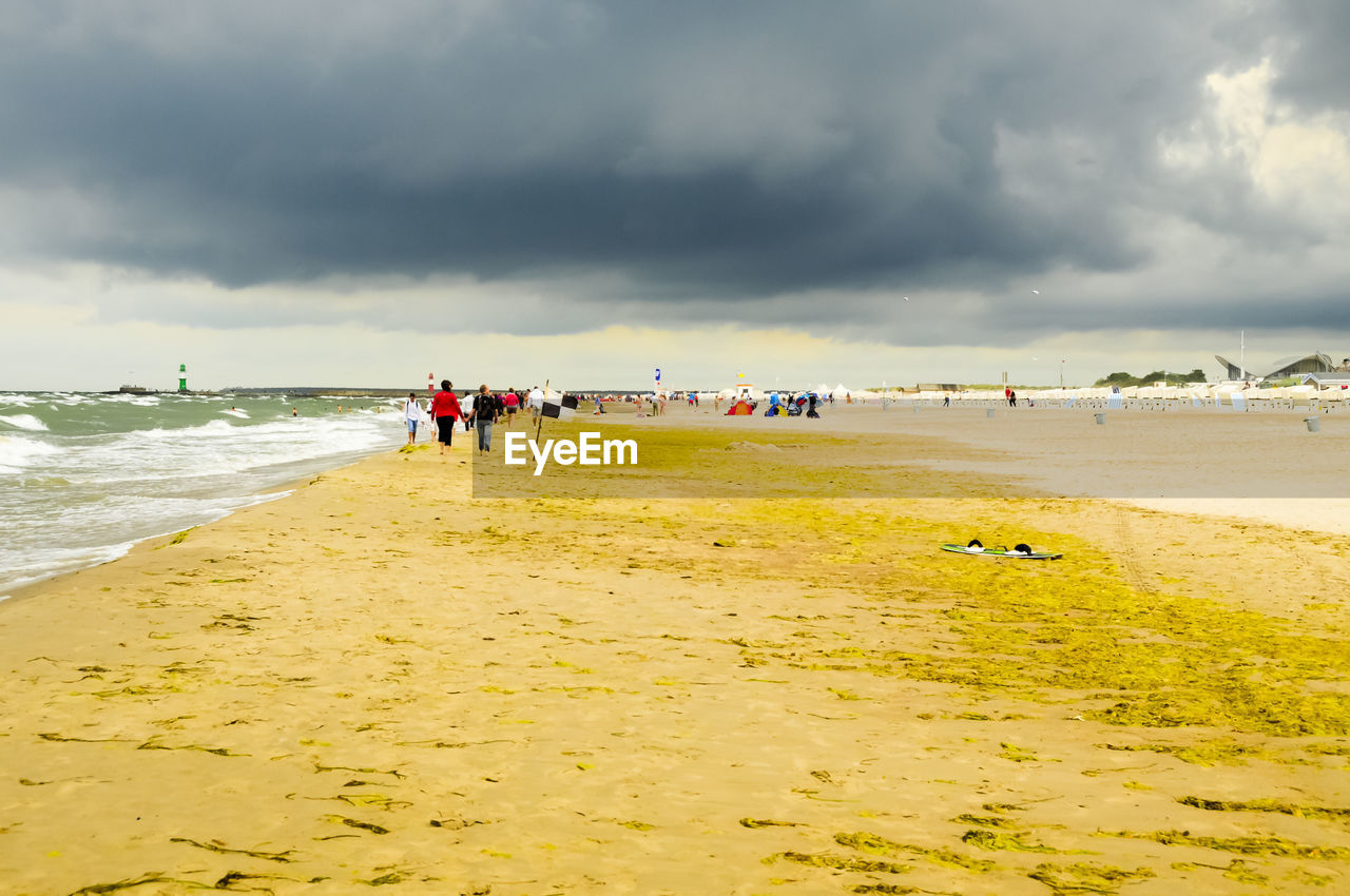 PEOPLE ON BEACH AGAINST SKY