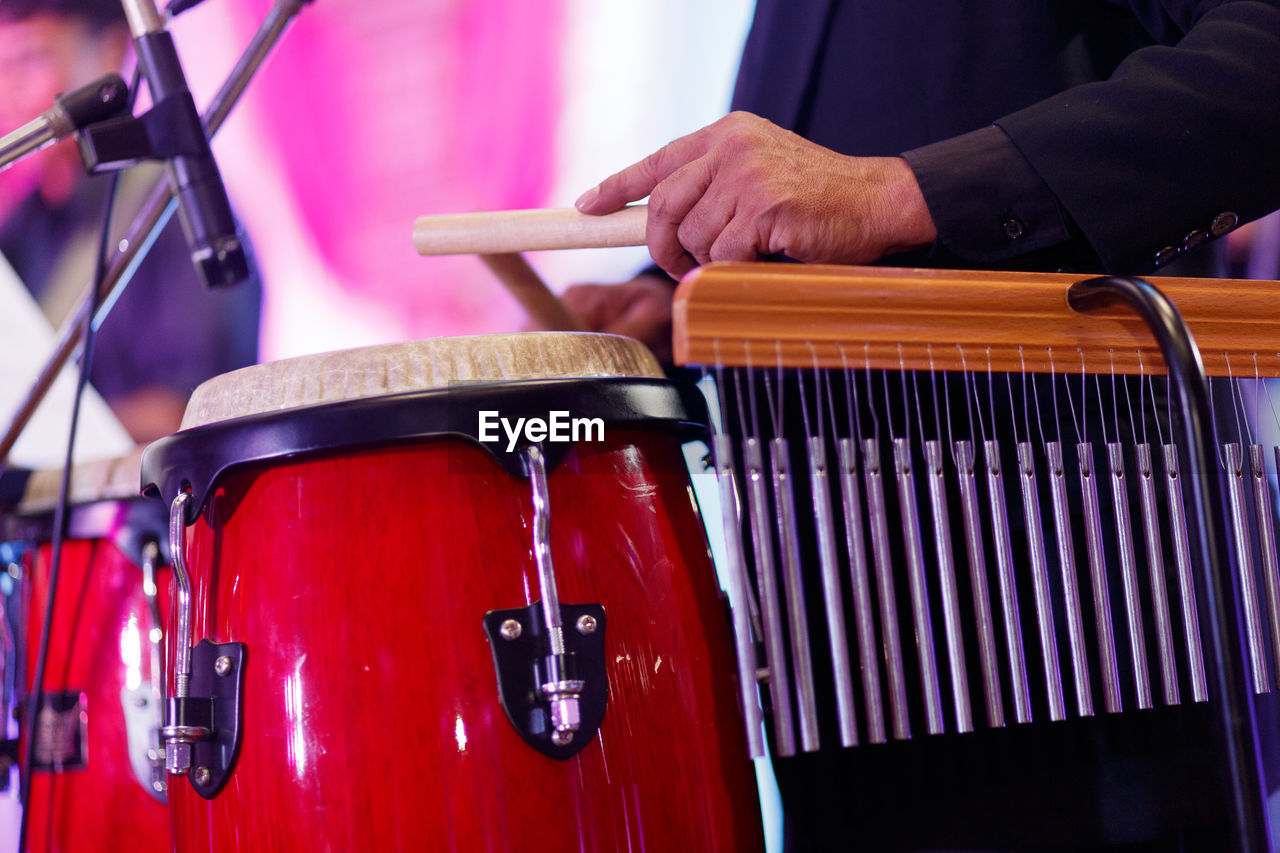 Midsection of musician playing instruments at music festival