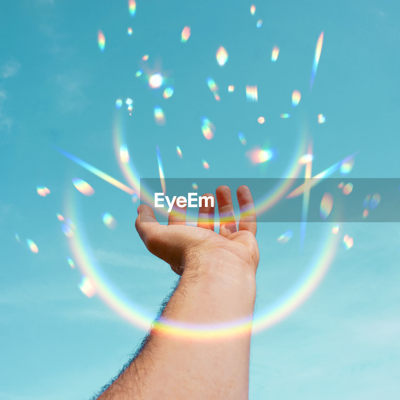 low section of woman holding illuminated string lights against blue sky