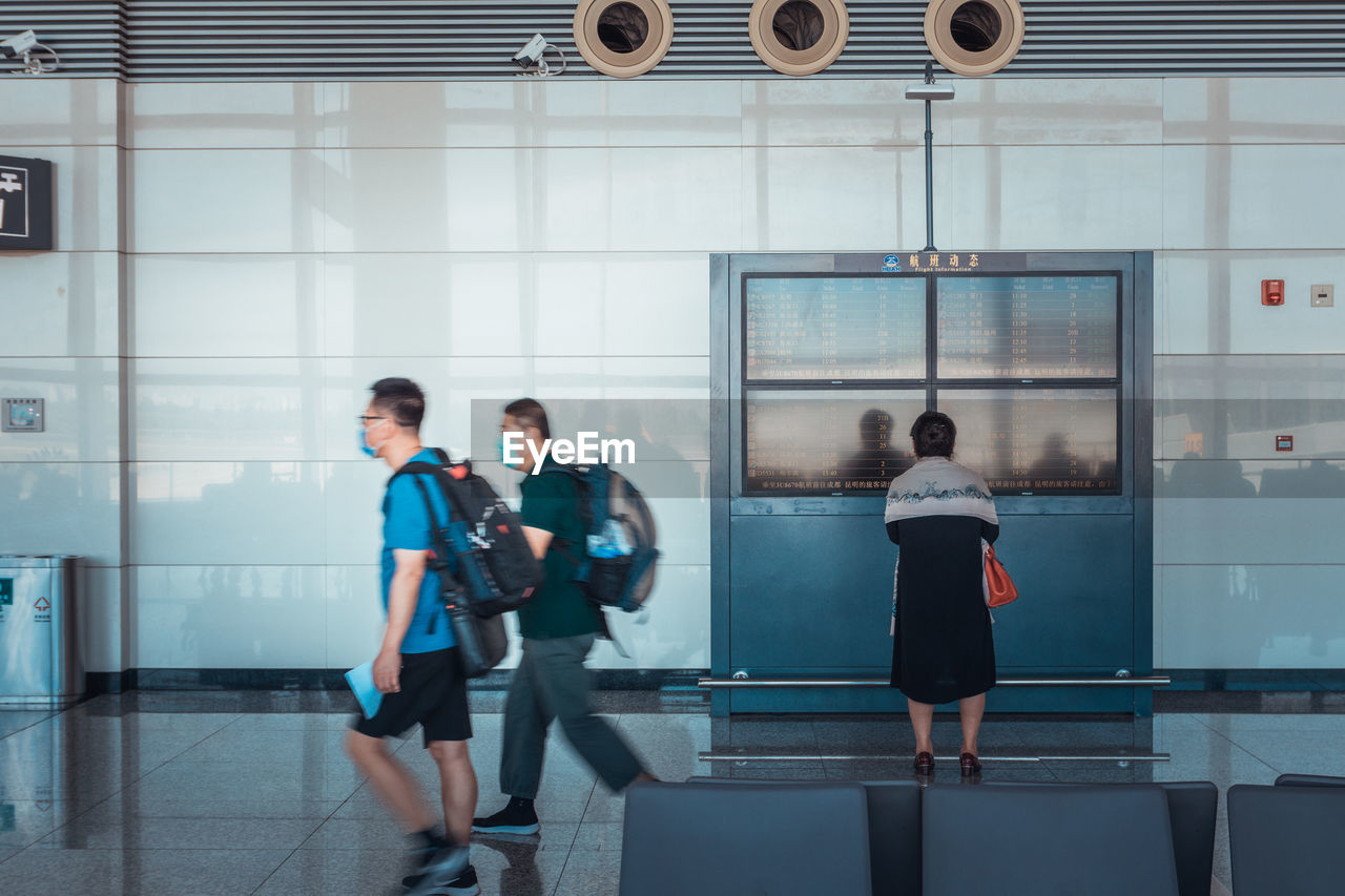 GROUP OF PEOPLE WALKING IN MODERN OFFICE BUILDING