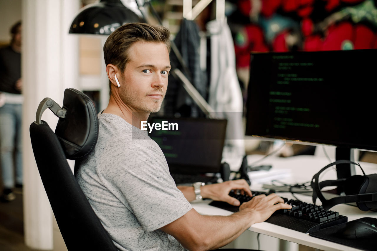 Portrait of male computer programmer working in office