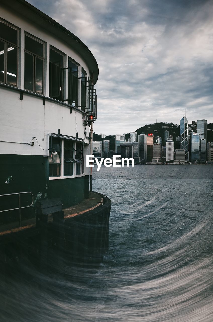 Buildings by sea against sky in city