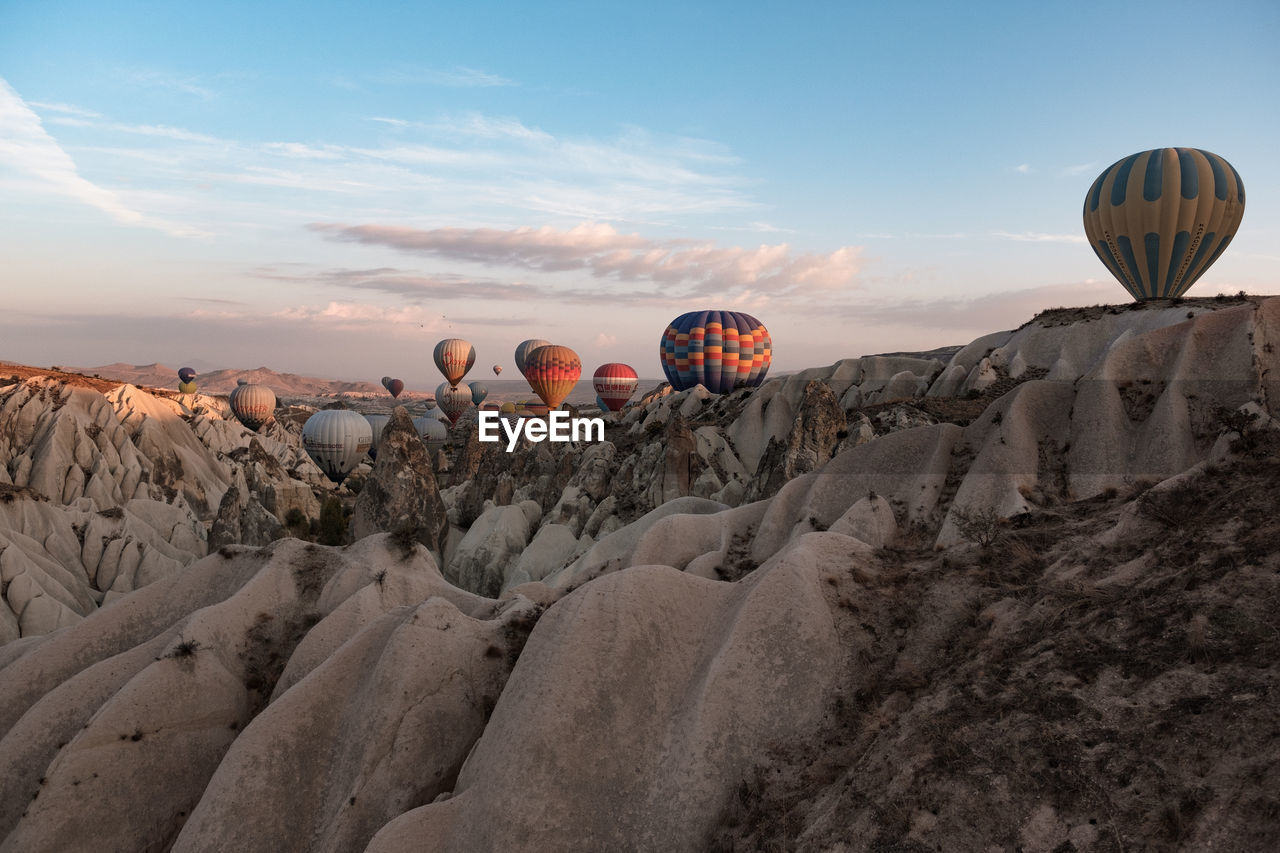 VIEW OF HOT AIR BALLOONS FLYING OVER ROCK FORMATION