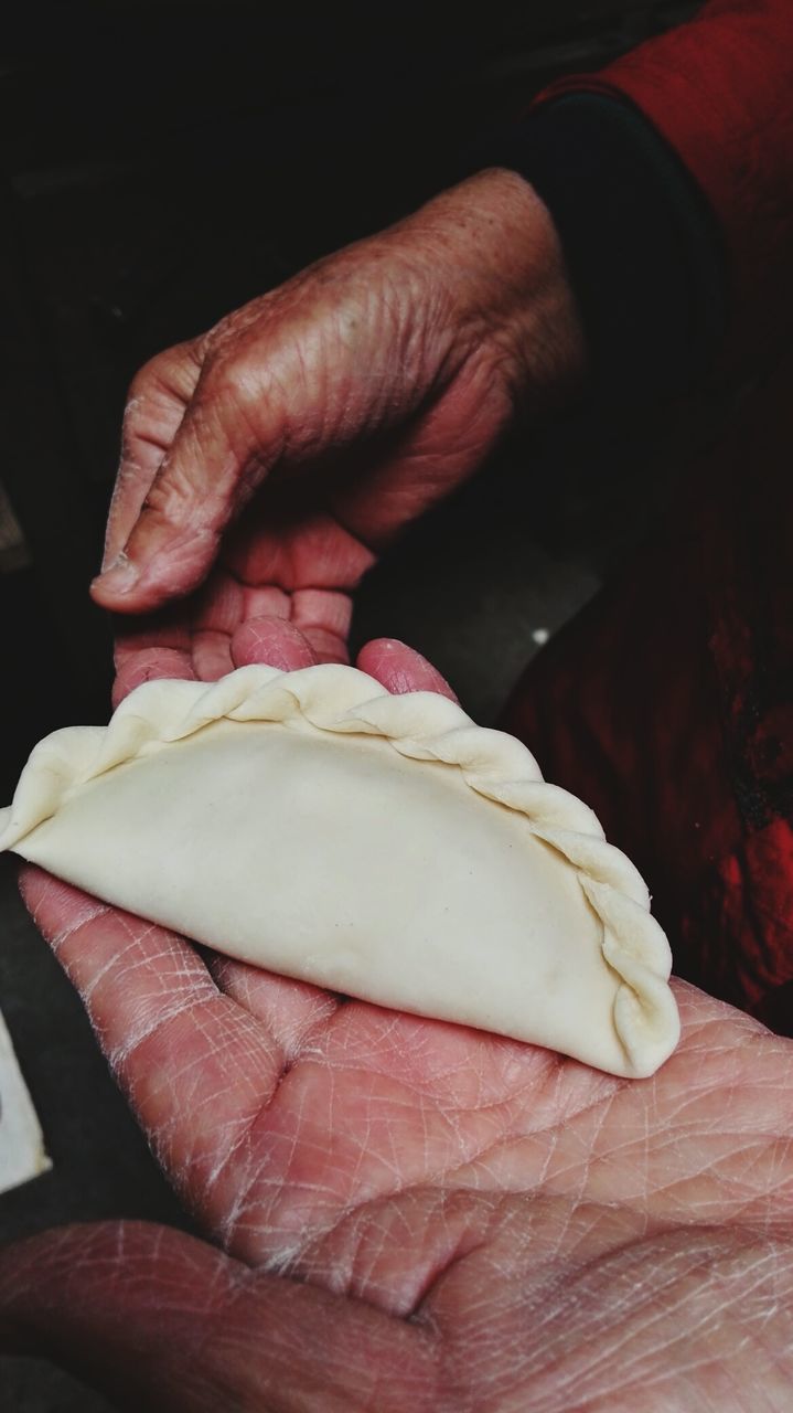 CLOSE-UP OF MAN HAND HOLDING BREAD