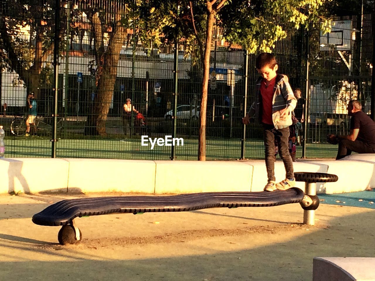 Full length of boy balancing on play equipment in park