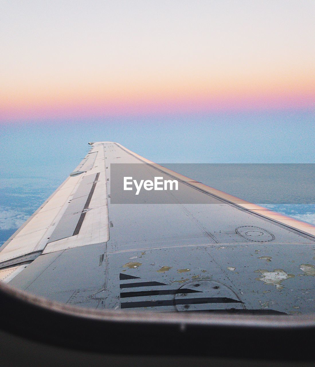 Close-up of airplane wing over sea against sky