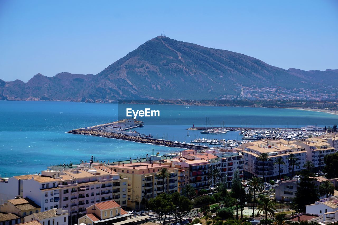 High angle view of city by sea against sky